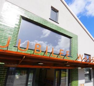 Jubilee Warehouse corten sign above front door with green tiles