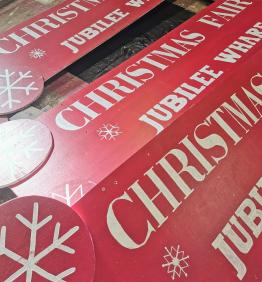 Handpainted Christmas Fair signs by Robotmother. White writing on red painted wood, wtih some simply dingbat snowflakes